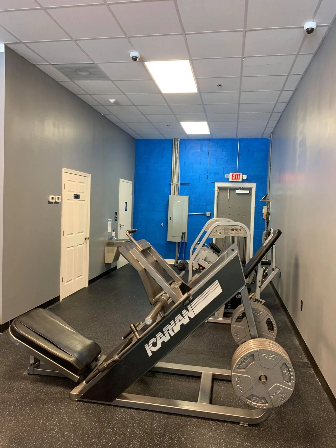 Plate-loaded leg press with 45 lb Olympic plates ready to load.